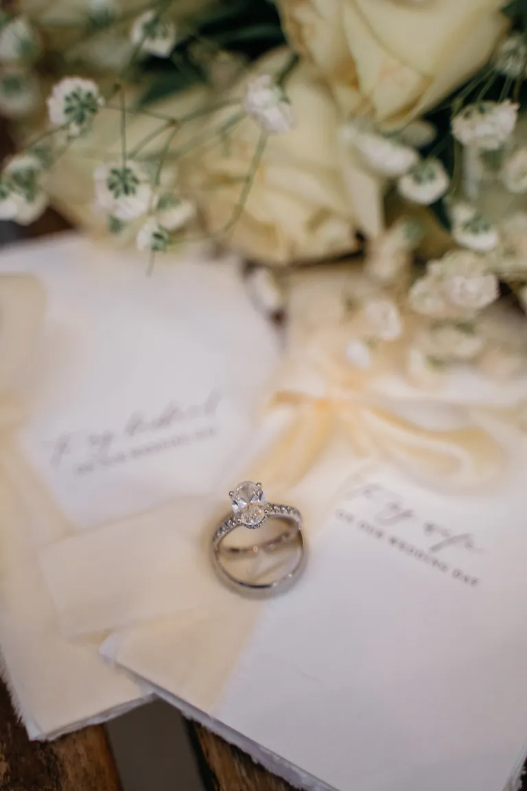Close-up of hands with wedding rings and a bouquet